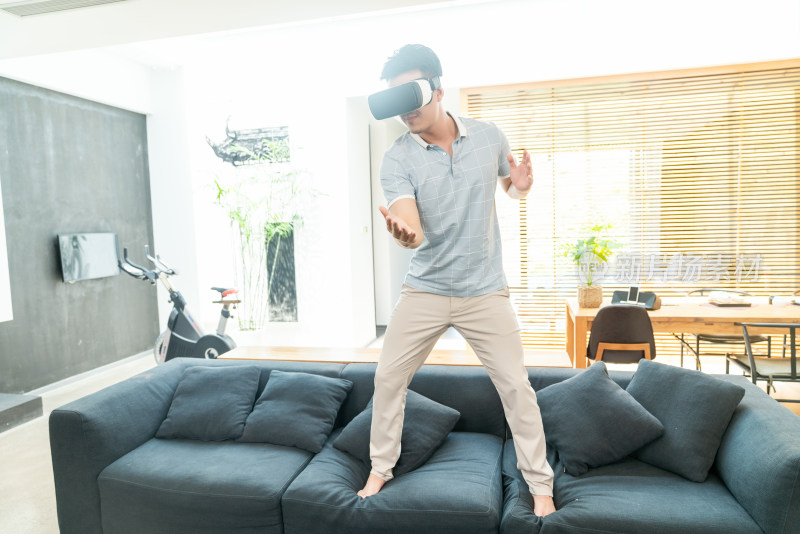 年轻男子在沙发上使用VR眼镜