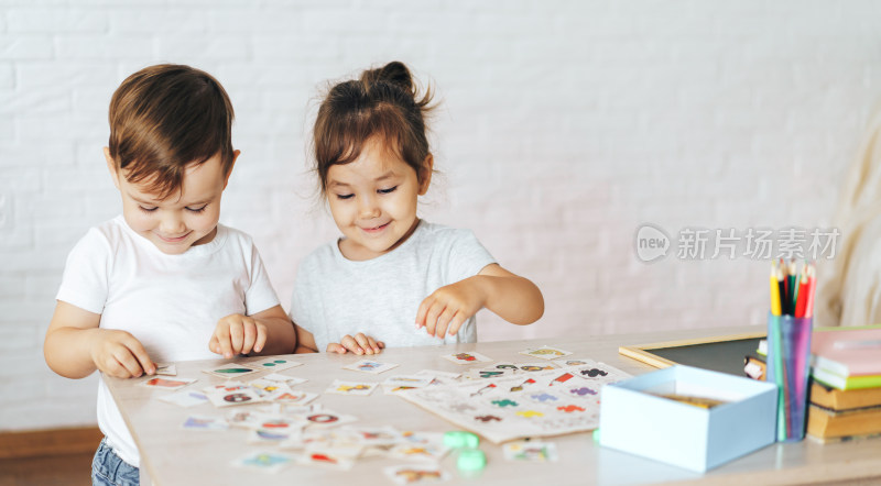 两小孩一起玩卡片游戏