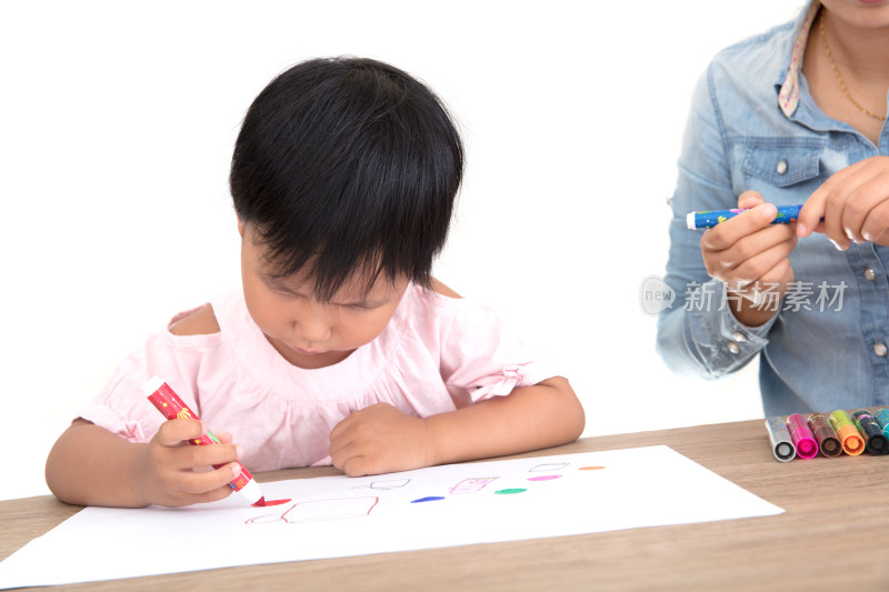 孩子母亲或幼儿园教师在手把手教小女孩绘画