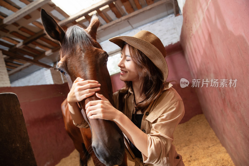 马厩里的青年女人抱着马