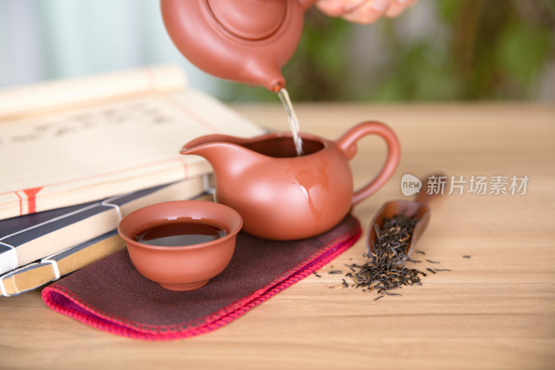 中国传统茶具和传统书籍及旁边的红玫瑰花