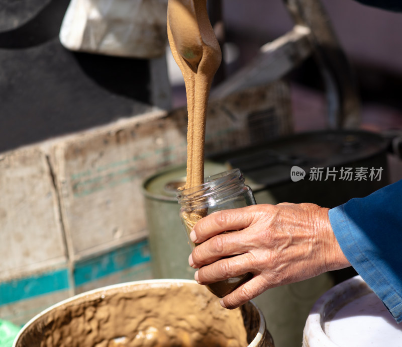 售卖芝麻酱的小贩在打芝麻酱