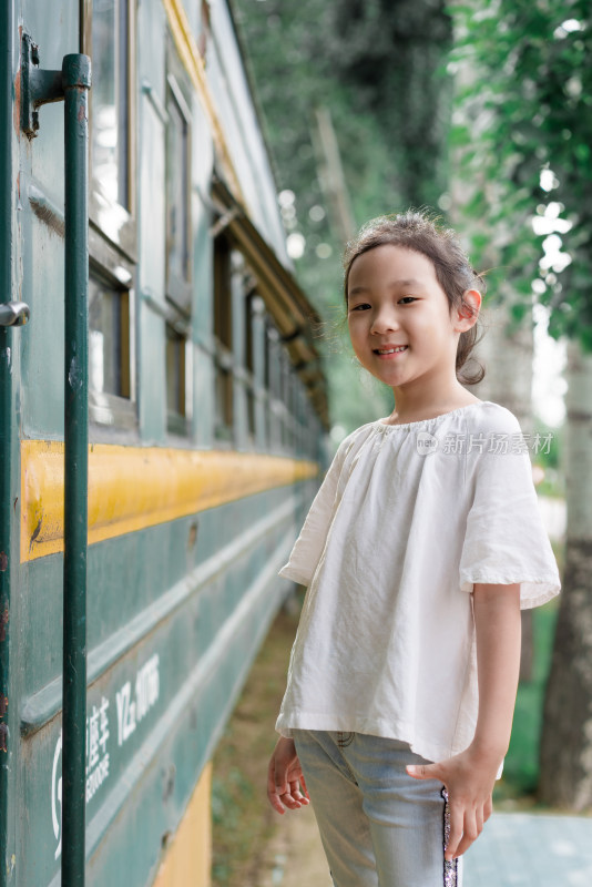 中国女孩站在年代久远的绿皮火车旁