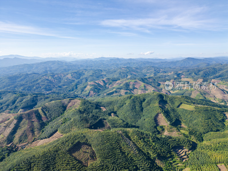 航拍蓝天白云下广阔无垠绿意盎然的山地景观