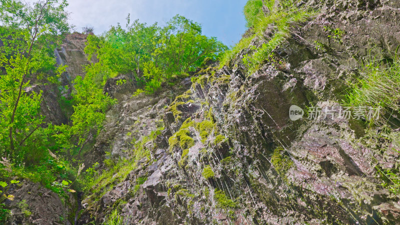 长满青苔的陡峭山崖瀑布