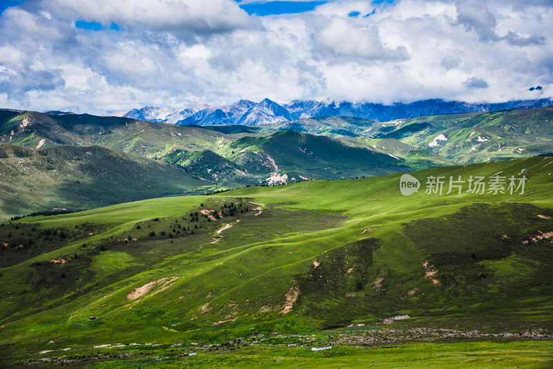 蓝天白云下广袤草原与连绵山峦自然风景