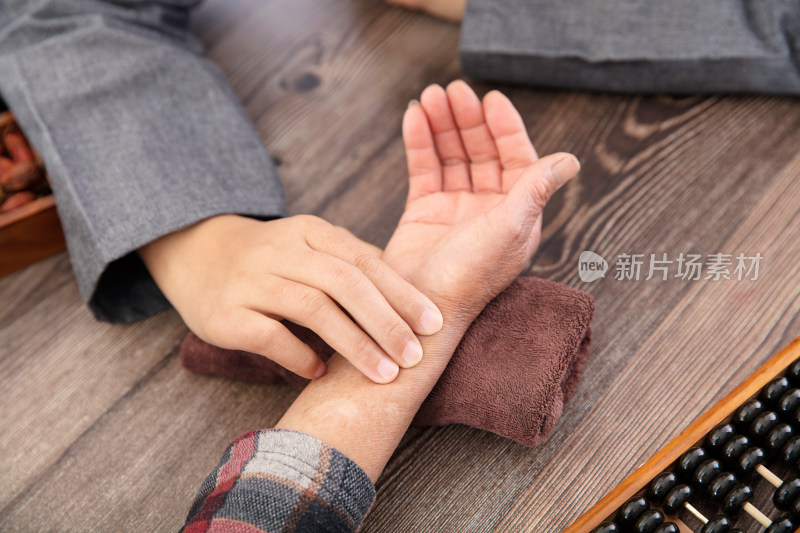 中医医生为患者诊脉的手部特写