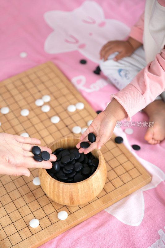 一只小手正把棋子放入棋盒中