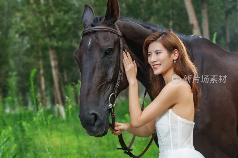 快乐的年轻女人亲昵的抚摸着马