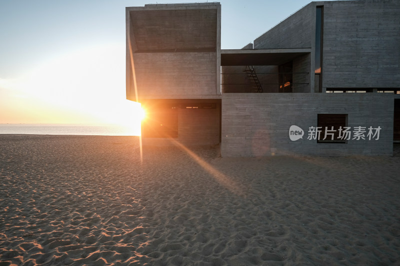 沙滩上的现代混凝土建筑日出景致