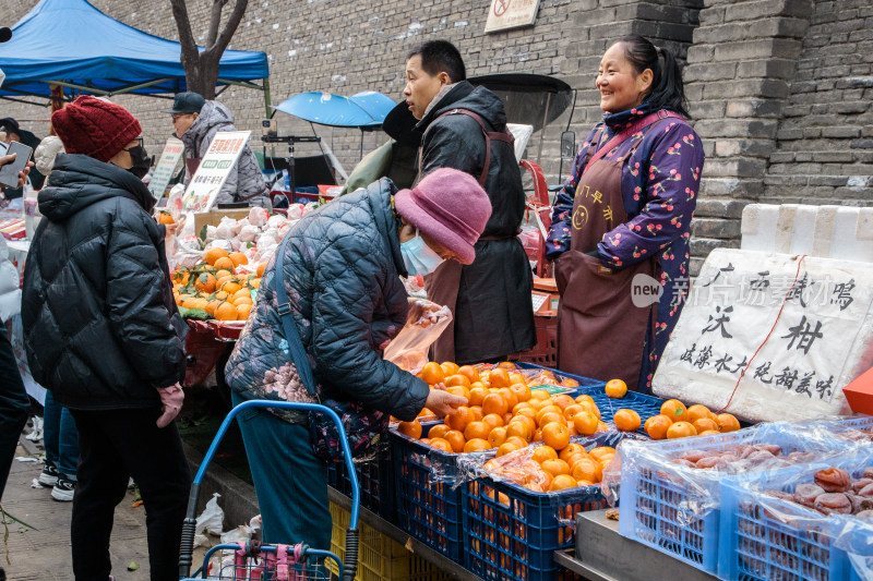 市民在街边水果摊选购橘子