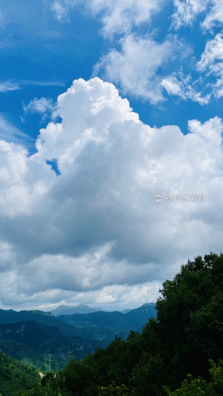 蓝天白云下的山峦绿植景观