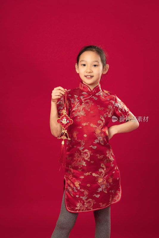 站在红色背景前穿旗袍的中国女孩