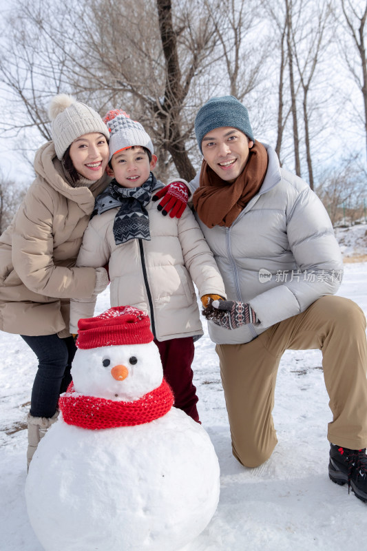 一家三口在雪地里堆雪人