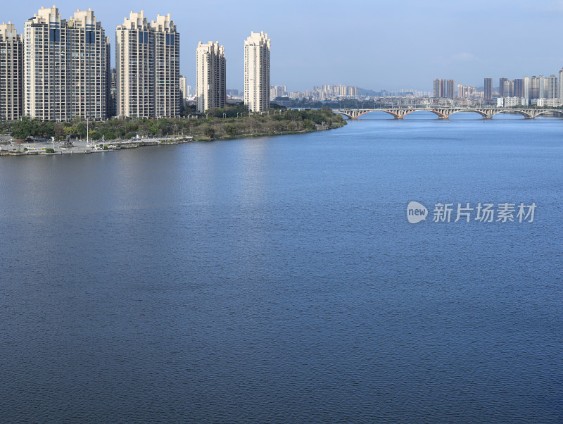 蓝天白云下，河流和现代建筑城市风光