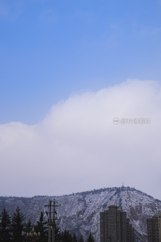 雪覆山丘与城市建筑景观