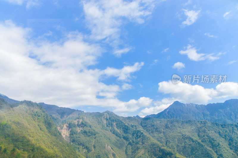 蓝天白云下的葱郁山脉自然风景