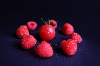 黑色背景下的树莓和小番茄特写镜头