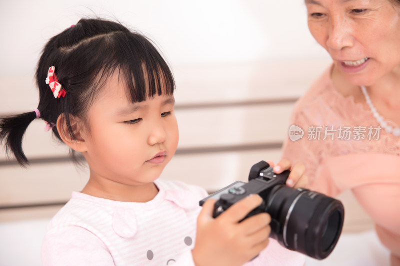 奶奶和孙女一起翻看相机里的照片