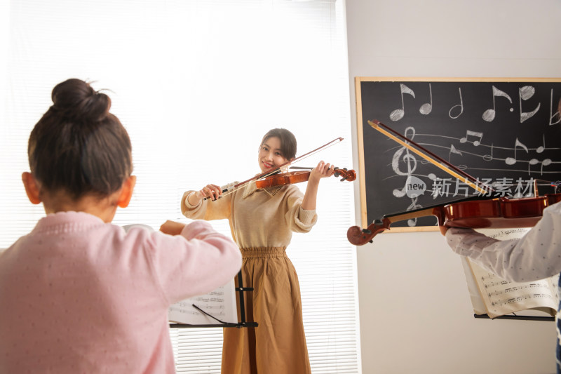 青年女人教儿童上音乐课