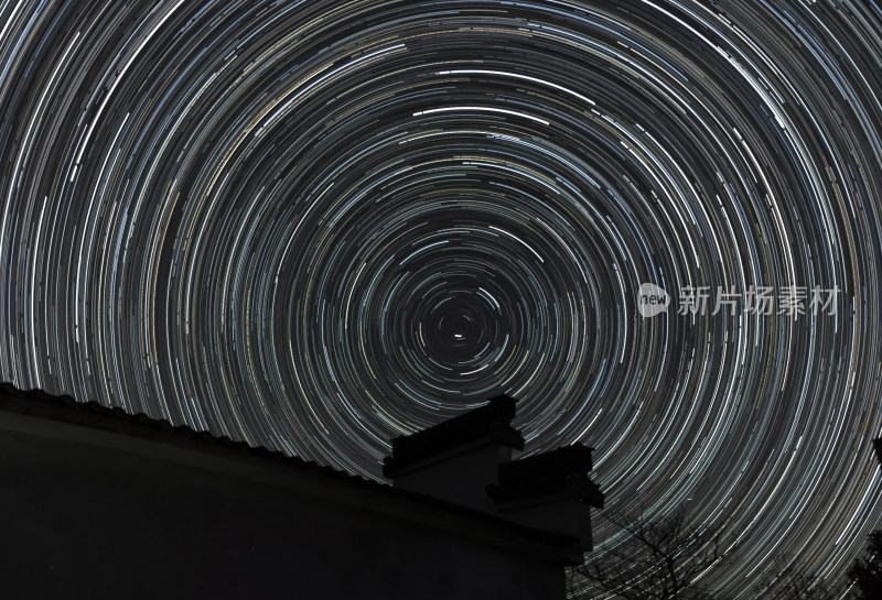 夜空下房屋上方的星轨景象