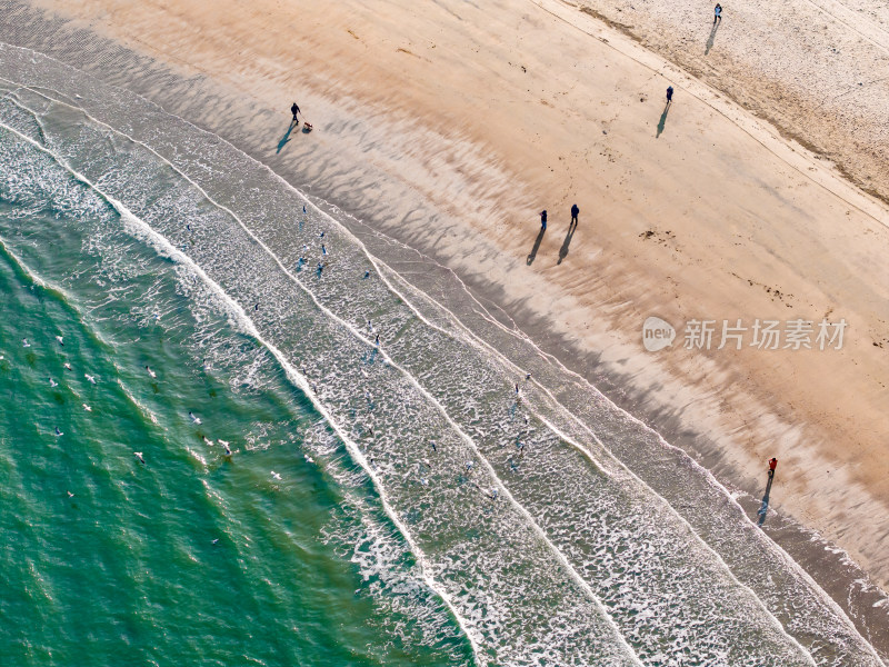 航拍沙滩上海浪及行人的景象