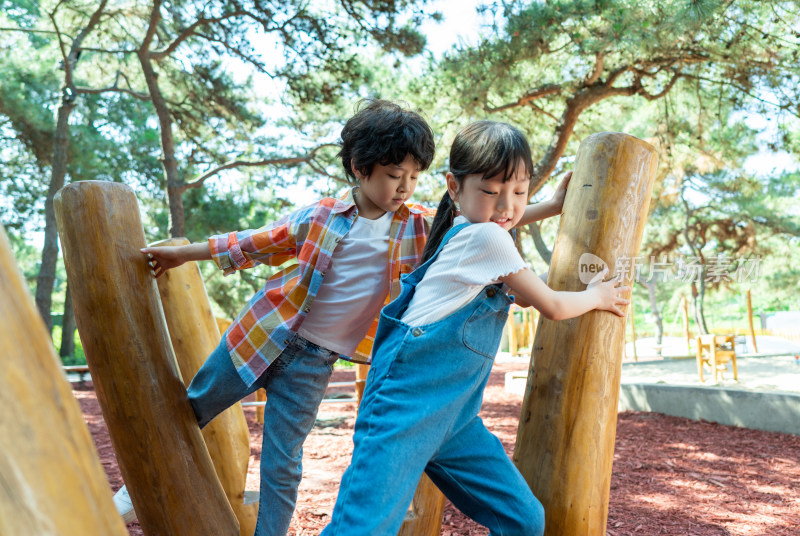 两个小孩子一起走木桩