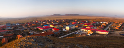 夕阳下内蒙坝上小红山景点的村庄牧场全景图