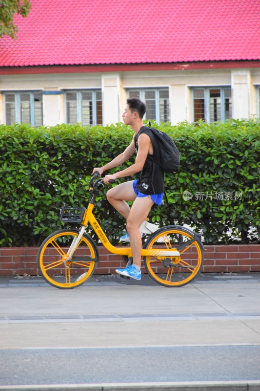 男子骑行黄色共享单车