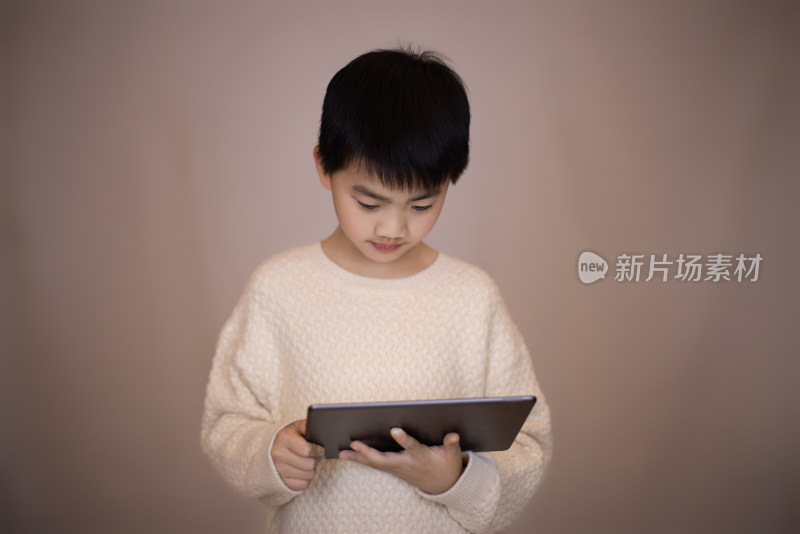 一个帅气的中国小男孩看平板电脑