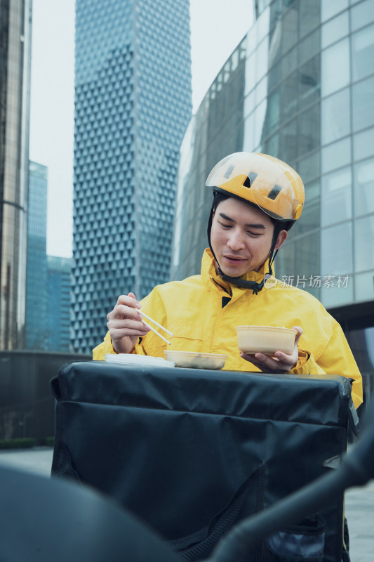 在户外吃饭的青年外卖员