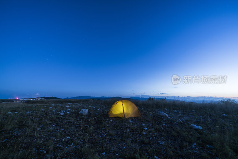 野外草地中放置着一顶黄色帐篷