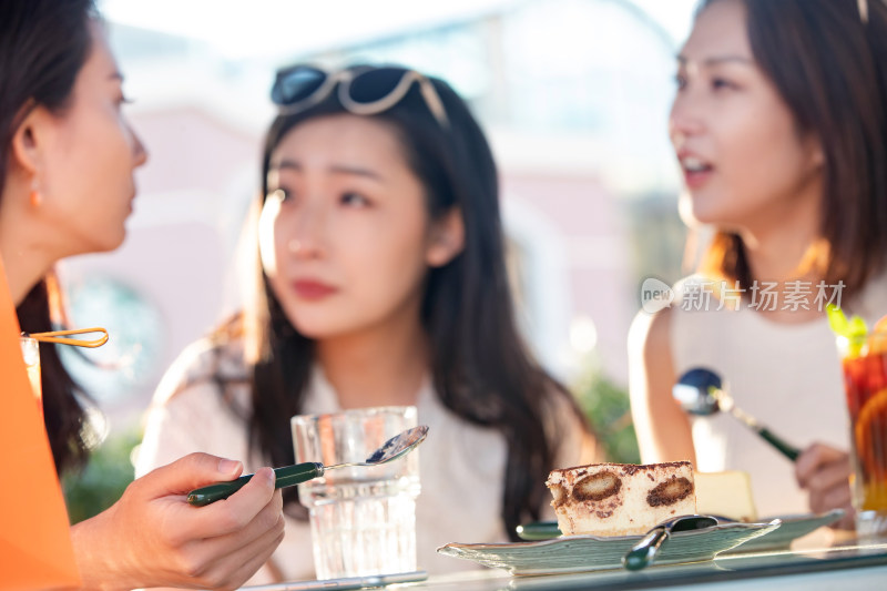 青年女人坐在露天咖啡馆聊天