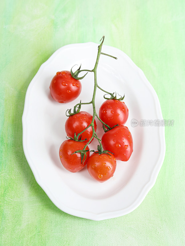 白色碟子上装着的新鲜水果西红柿番茄