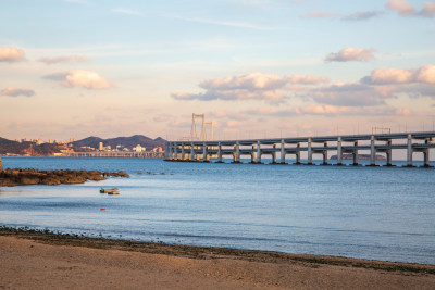 黄昏日落时的大连黑石礁公园海滩和跨海大桥