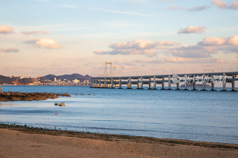 黄昏日落时的大连黑石礁公园海滩和跨海大桥