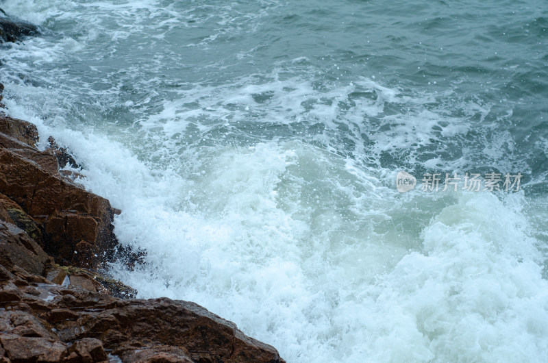 海浪拍打岸边岩石的壮观景象