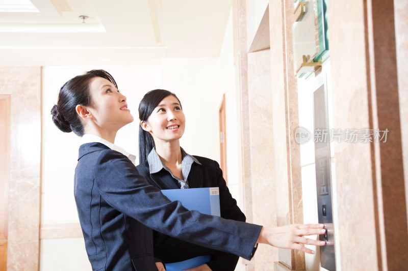 两个年轻商务女士等待电梯
