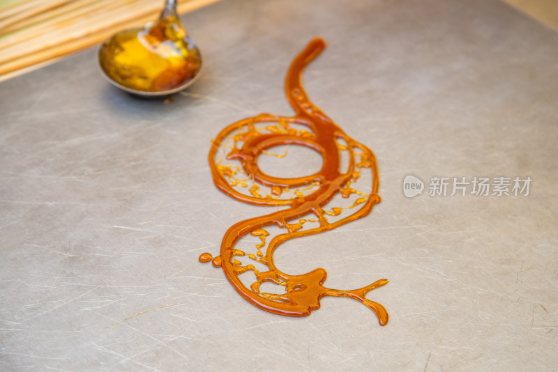 民间手艺人制作蛇造型糖画