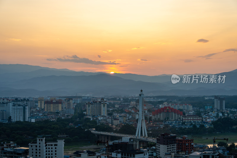 夕阳下的西双版纳城市与连绵山脉交相辉映