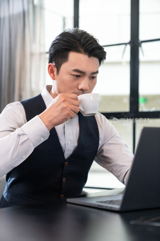 一个商务男士坐在会议室办公喝咖啡