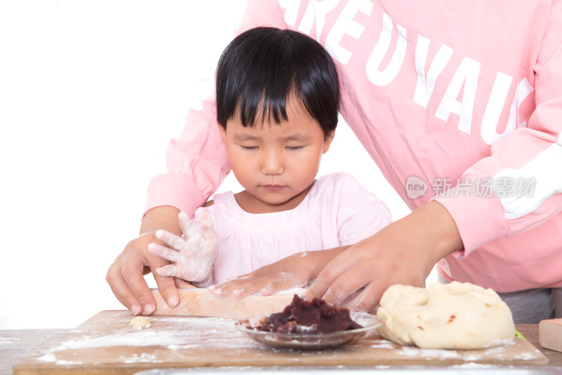 中国妈妈在教自己的女儿学习做中秋节的月饼