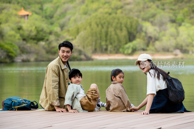 快乐家庭坐在湖边看风景