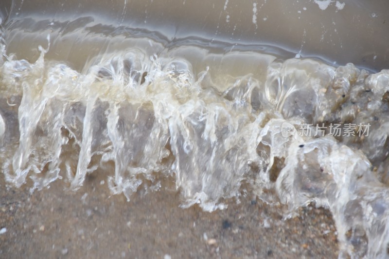 海浪拍打沙滩的动态瞬间