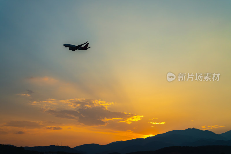 日落时飞机在天空中飞行的低角度视图