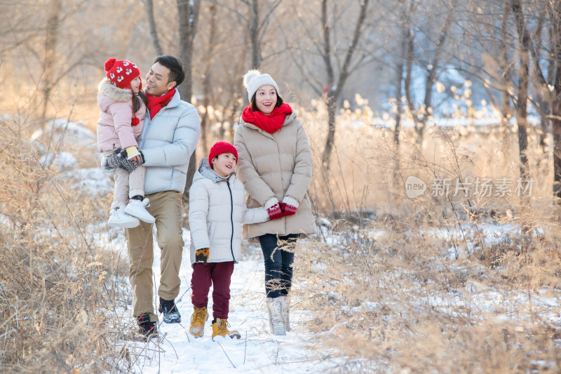 快乐家庭在雪地里散步