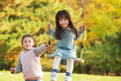 两个女孩在公园里荡秋千