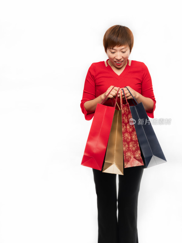 站在白色背景前手提购物纸袋的中国女性