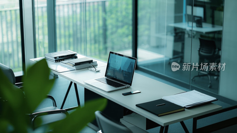 现代办公桌上的笔记本电脑与文件