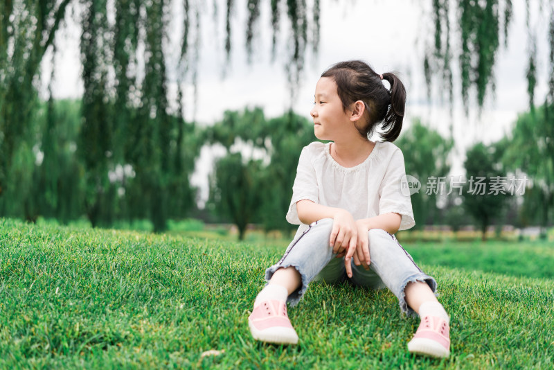 夏天坐在草地上的中国女孩